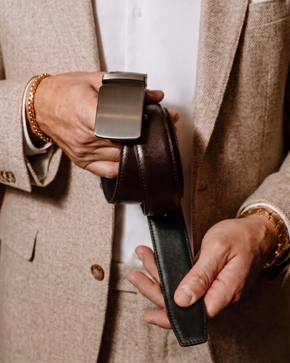 Monolith Shale belt held against a tailored jacket